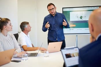 Oliver Frankfurth beim Beraten — Team im Hintergrund